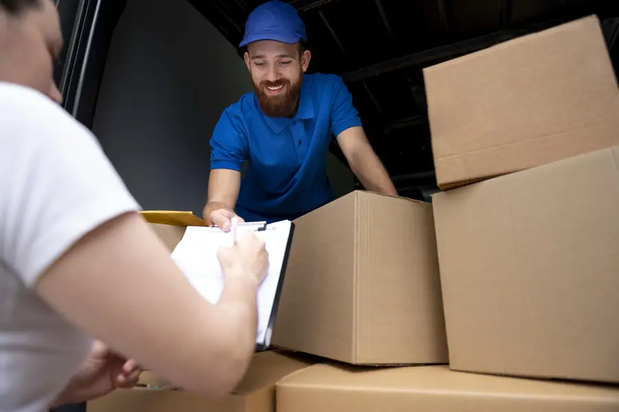 Entregador conferindo as caixas com as peças junto ao cliente