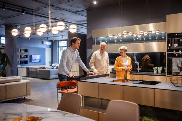 Projetista apresentando uma cozinha planejada a clientes no showroom